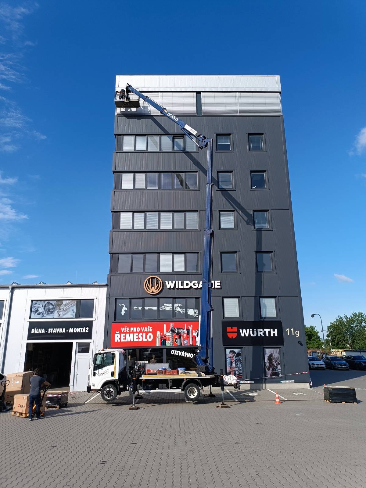 Oprava žaluzií na fasádě výškové budovy z plošiny Isuzu Cela DT 28